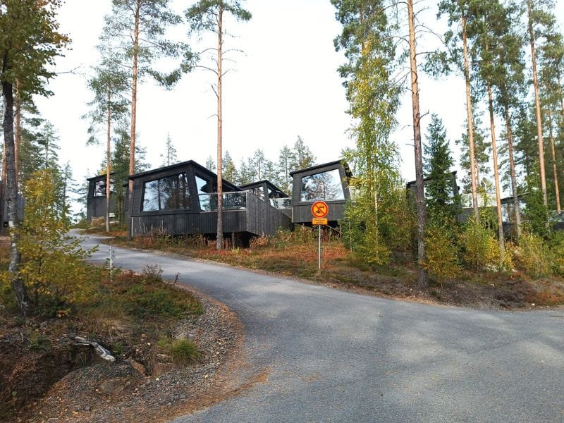 Järvisydämen uudisrakennuksia. Korkea harmaa rakennus parvekkeilla, ympärillä vihreää puustoa ja nurmikkoa kirkkaan sinisen taivaan alla