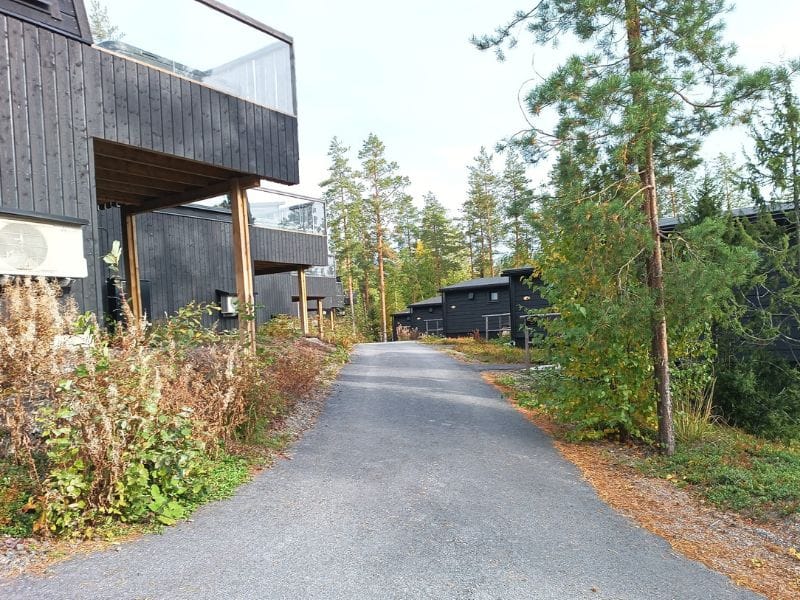 Järvisydämen uudisrakennuksia. Korkea harmaa rakennus parvekkeilla, ympärillä vihreää puustoa ja nurmikkoa kirkkaan sinisen taivaan alla